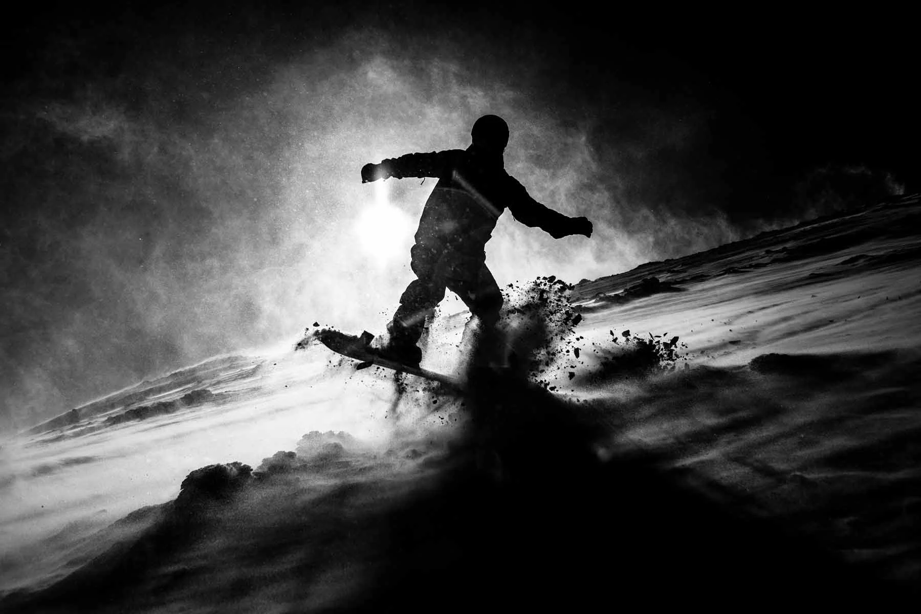 Silueta de un snowboarder en una pendiente nevada con copos de nieve frente a un cielo claro. Silueta de un snowboarder en una pendiente nevada con copos de nieve frente a un cielo claro.