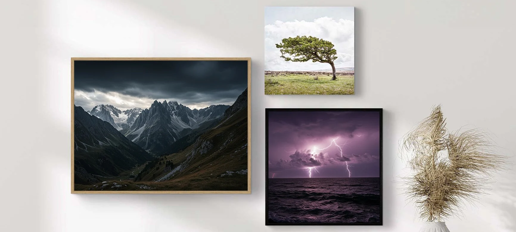 Three weather photographs on a white wall, including a mountain landscape with dark clouds, a tree in a meadow, and a thunderstorm over the sea.