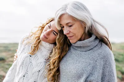 Droit d'auteur pour les photographes 1 Deux femmes sont debout à l'extérieur, appuyées l'une contre l'autre, toutes deux portent des pulls chauds en maille claire.