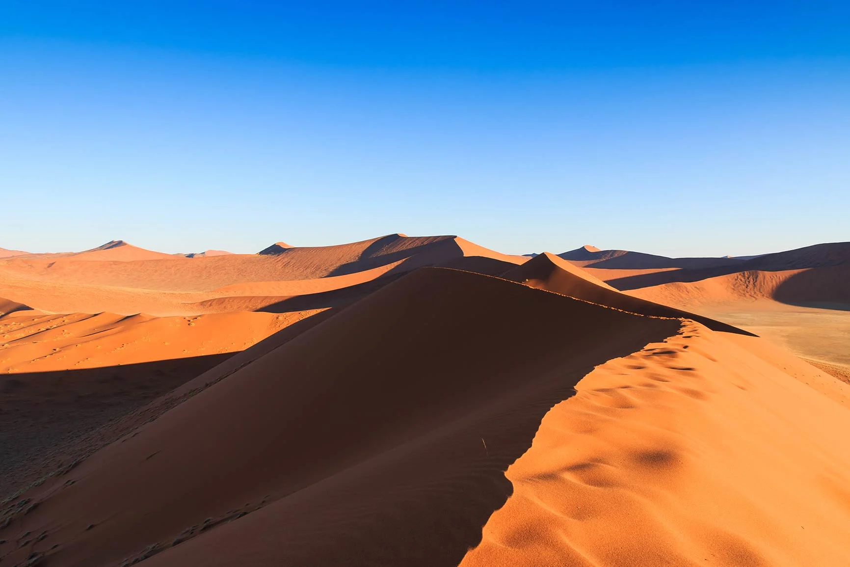Sand dunes Landscape photography featuring sand dunes under a clear blue sky.