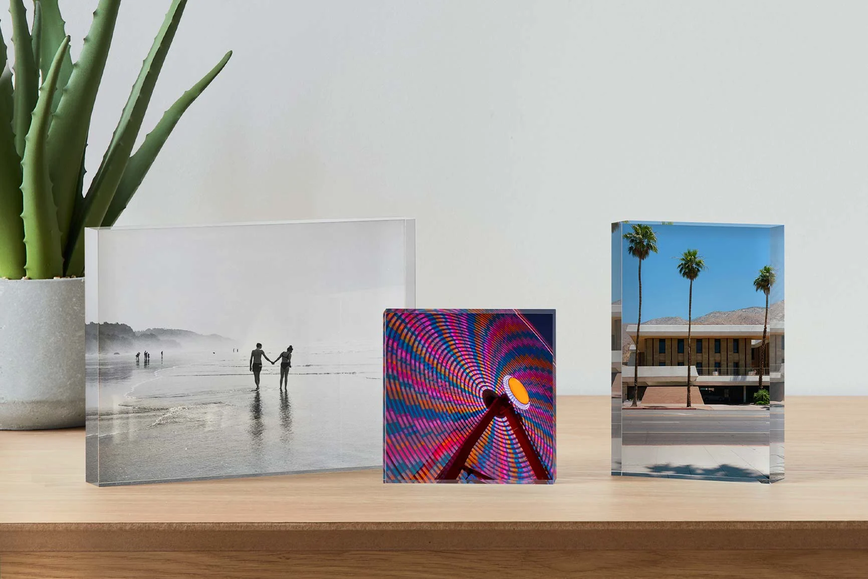 Three photo acrylic blocks on a wooden table with different motifs. Three photo acrylic blocks on a wooden table with different motifs.