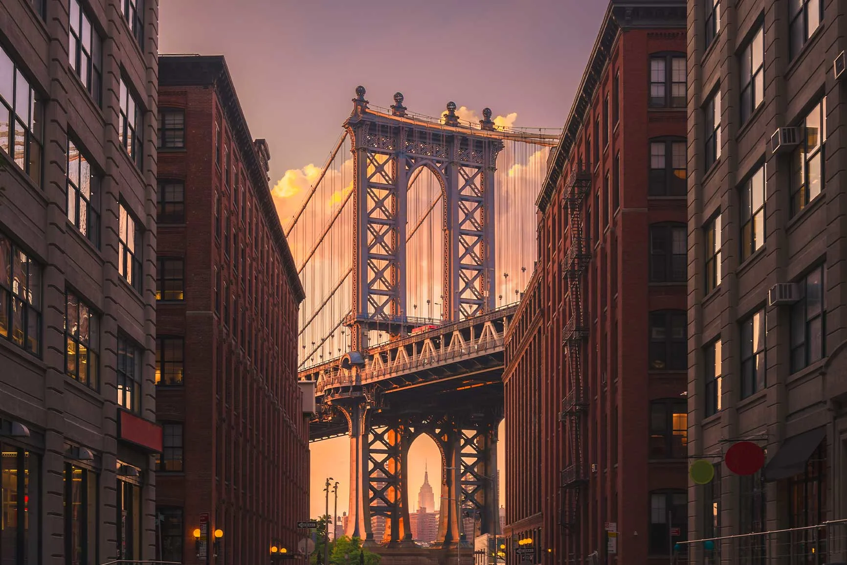 Vista del Manhattan Bridge al tramonto, incorniciato dagli edifici in mattoni di New York City. Vista del Manhattan Bridge al tramonto, incorniciato dagli edifici in mattoni di New York City.