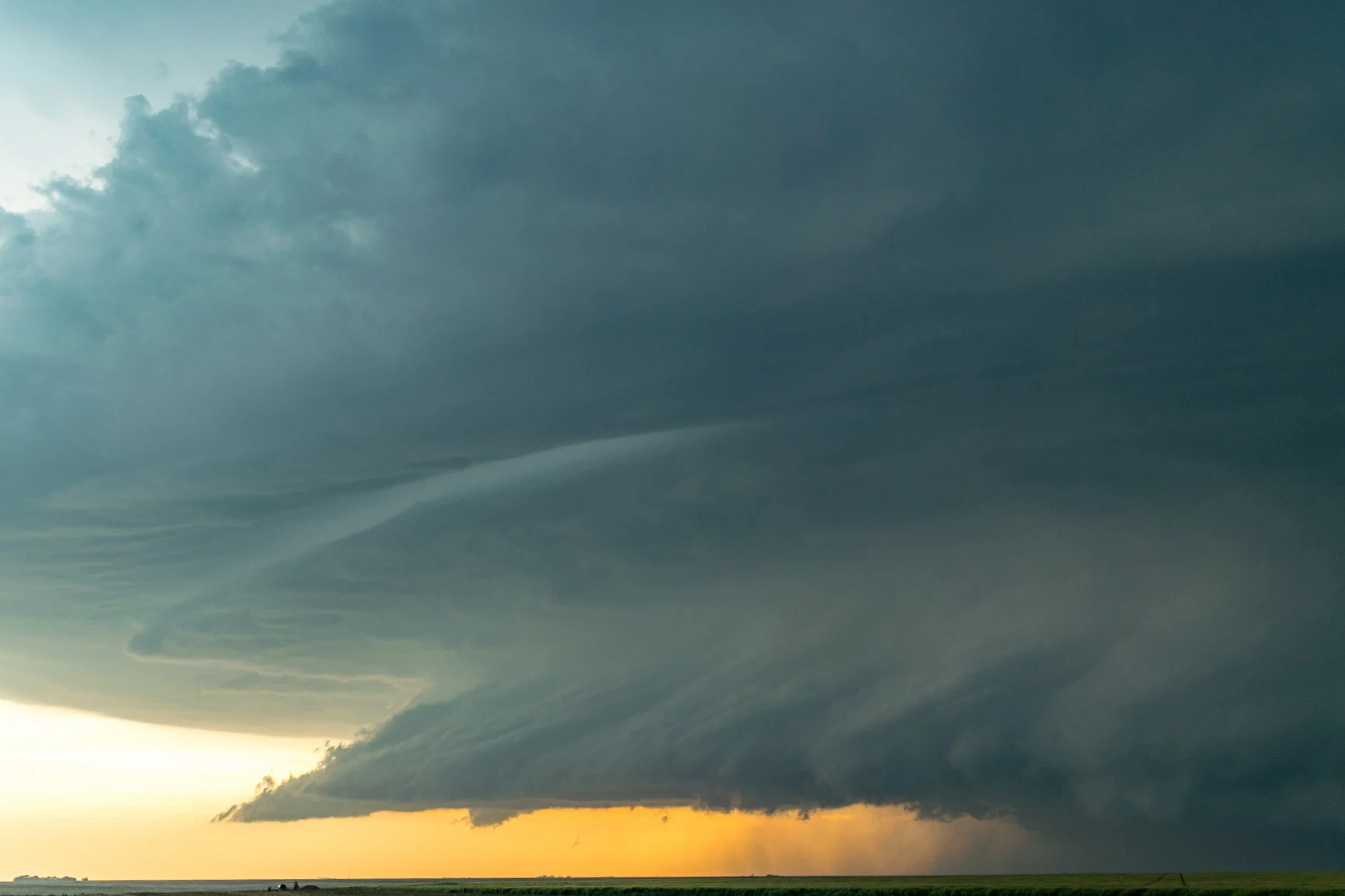 Storm cloud formation A formation of storm clouds over a flat landscape at sunset.