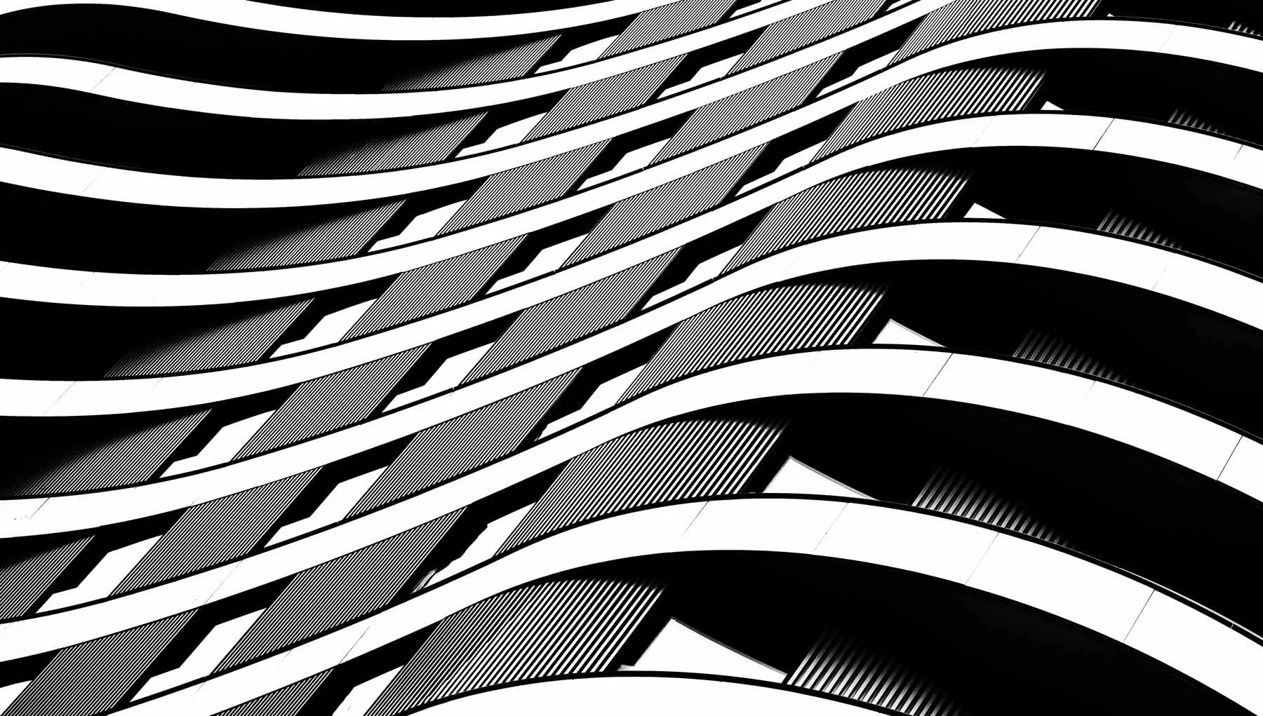 Imagen en blanco y negro de varios balcones curvos repetitivos de un edificio con sombras. Imagen en blanco y negro de varios balcones curvos repetitivos de un edificio con sombras.