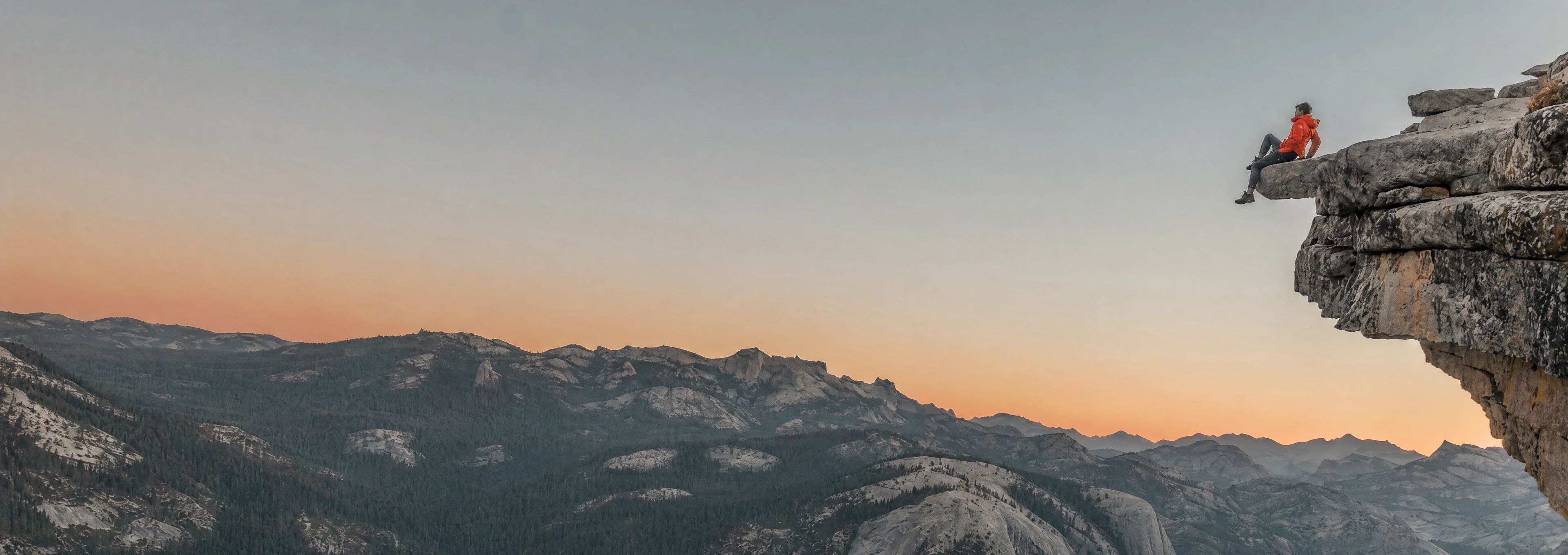Man watching the sunset on top of a mountain