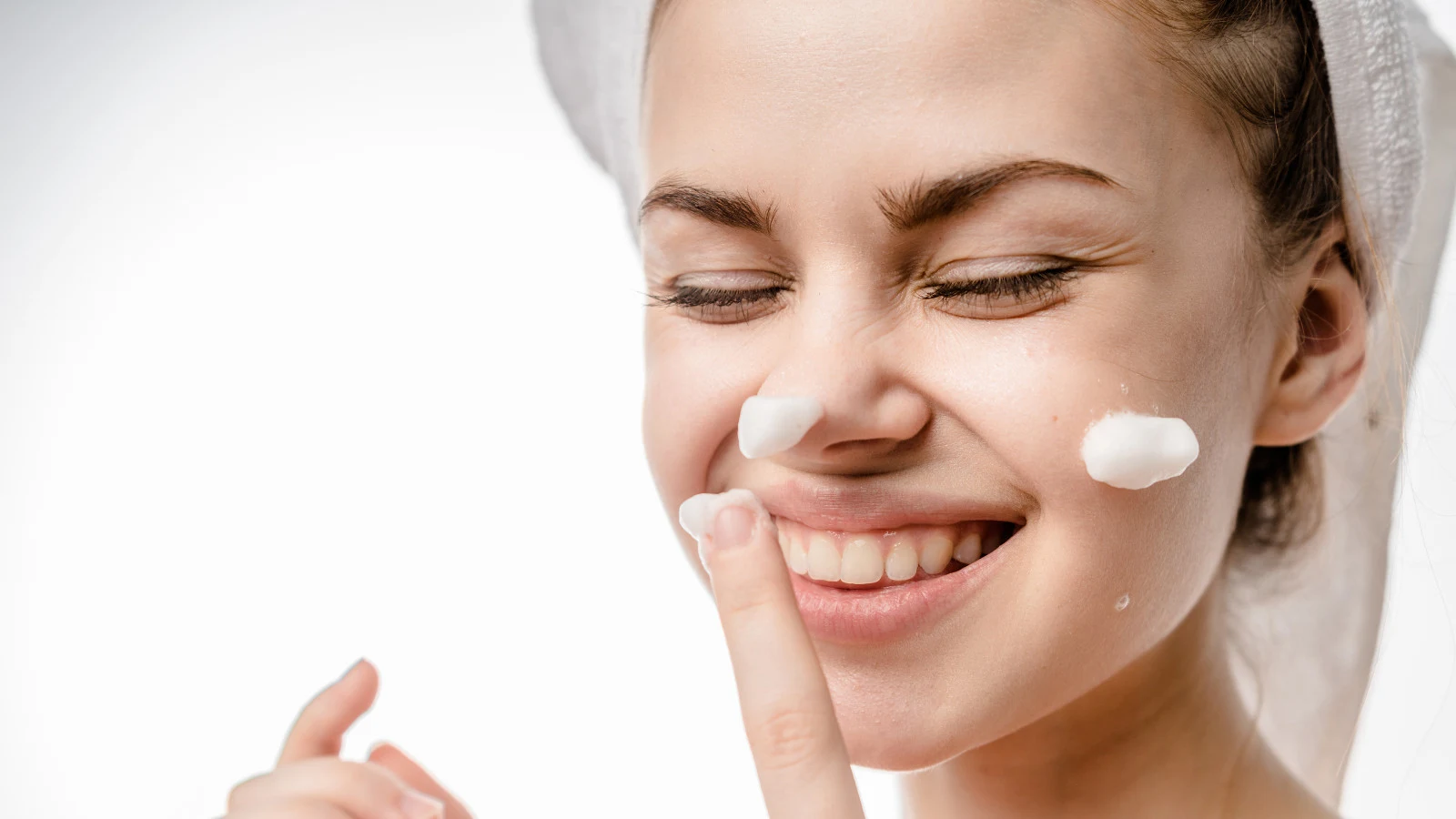 Mujer sonriendo mientras se aplica crema de afeitar