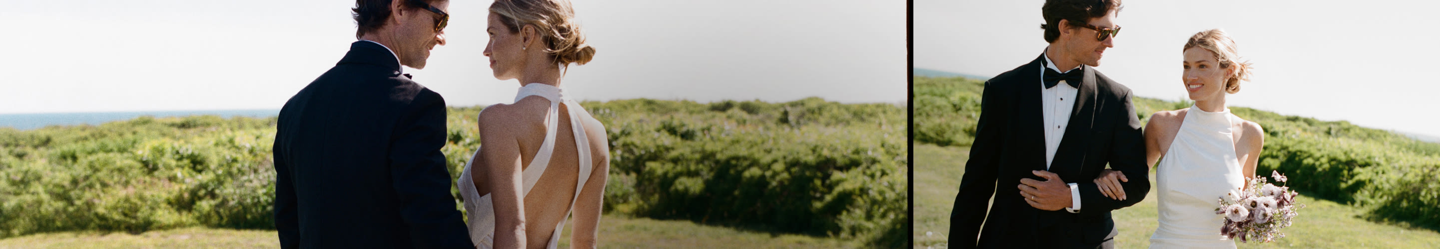 Bride and groom in formal wedding attire standing together outdoors with green landscape and ocean view in background