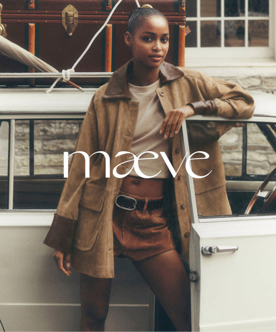 Woman in tan jacket and brown skirt leaning against white car with text "maeve" overlaid on image