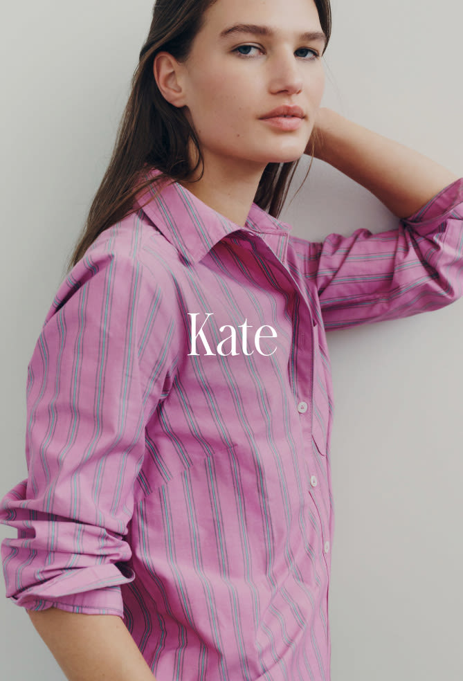 Woman wearing pink striped button-up shirt with hand near face, text reads Kate on neutral background