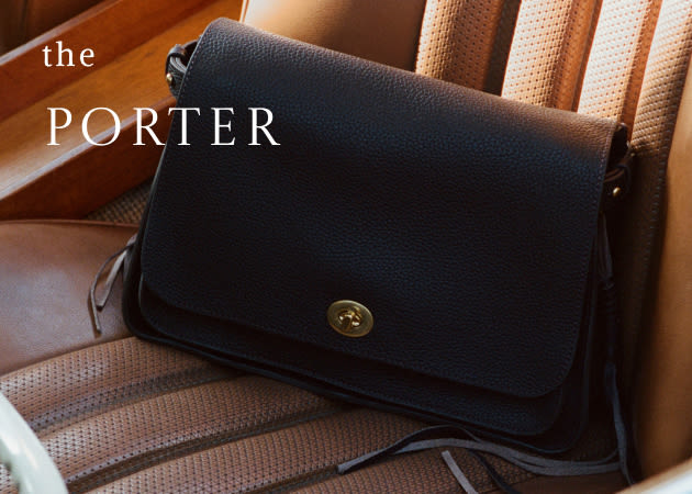 Black leather crossbody bag with brass button closure on striped chair with text "the PORTER" in white letters