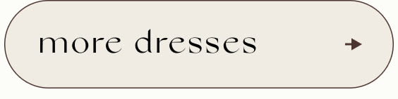Button with text 'more dresses' in black serif font on beige background with right-pointing arrow