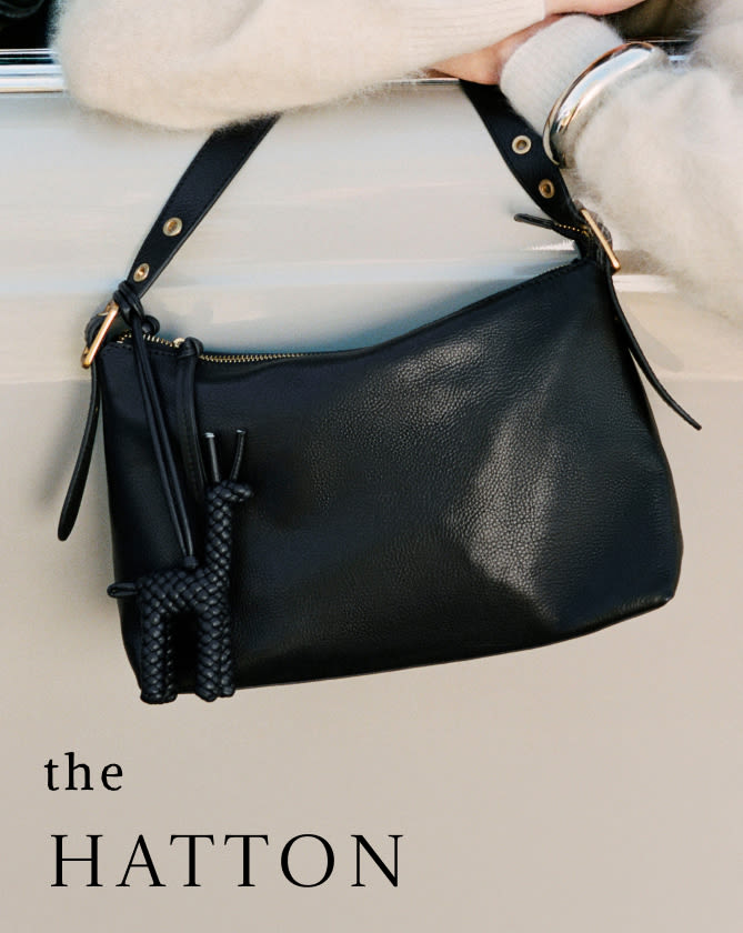 Person wearing cream sweater holding black leather shoulder bag with braided strap detail and tassel. Text reads "the HATTON"