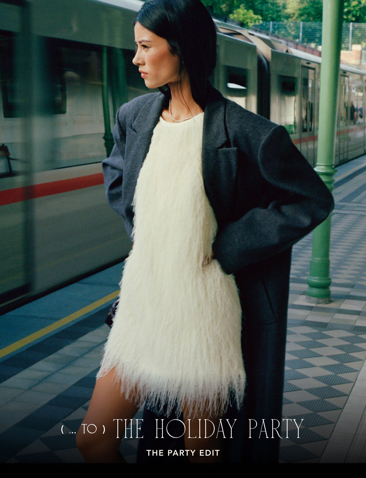 Woman in dark coat over white feathered dress at train station. Text reads: TO THE HOLIDAY PARTY THE PARTY EDIT