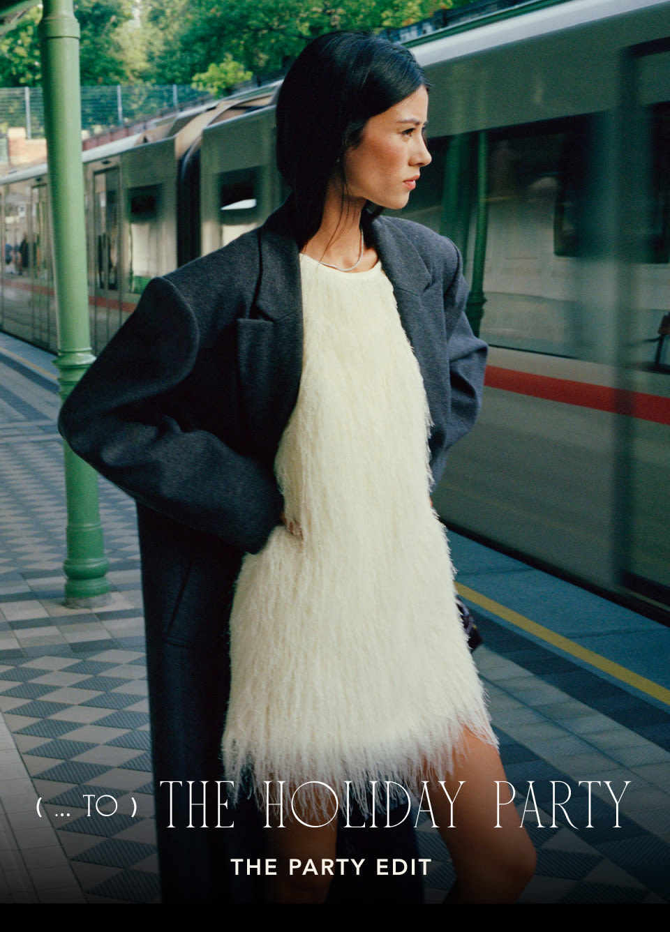 Woman in dark coat over white feathered dress at train station. Text reads: TO THE HOLIDAY PARTY THE PARTY EDIT