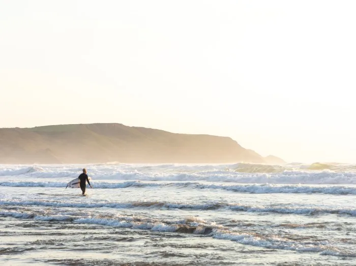 Surfer Walking out into the Ocean - Bude, Cornwall,