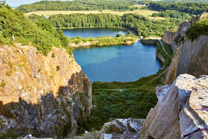 Blick auf den See Opalsøen auf Bornholm. Der See ist von hohen Granitfelsen umgeben.
