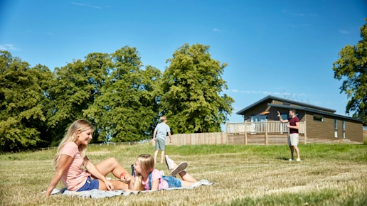 Family relaxing in the grounds of Ribblesdale Lodges (RIDL) Gisburn, Yorkshire Dales, England, UK.