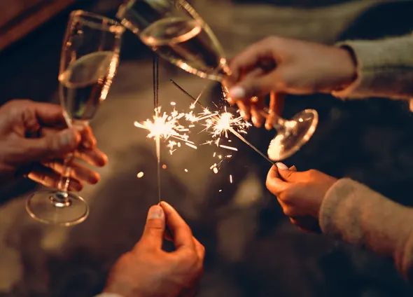 Nyårsfirande i stuga med tomtebloss och champagne.