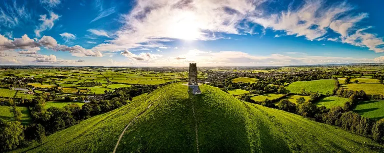 Glastonbury Tor near Glastonbury in the English county of Somerset, topped by the roofless St Michael's Tower, UK