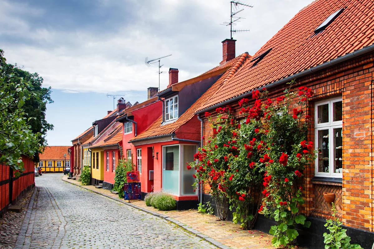 Kopfsteinpflasterstraße mit bunten Häusern auf Bornholm in Dänemark.