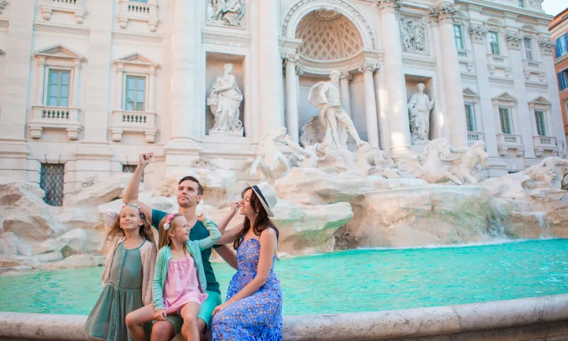 Eine Familie wirft Münzen in den Trevi-Brunnen in Rom.