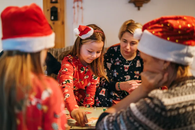 Eine Familie spielt ein Brettspiel an Weihnachten.