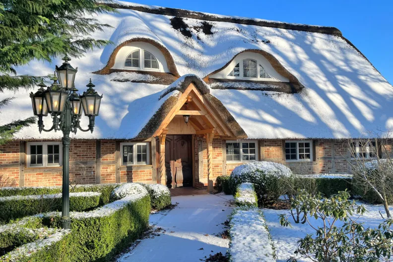 Ein idyllisches Ferienhaus in einer verschneiten Winterlandschaft in Kalbe-Sittensen, Deutschland.