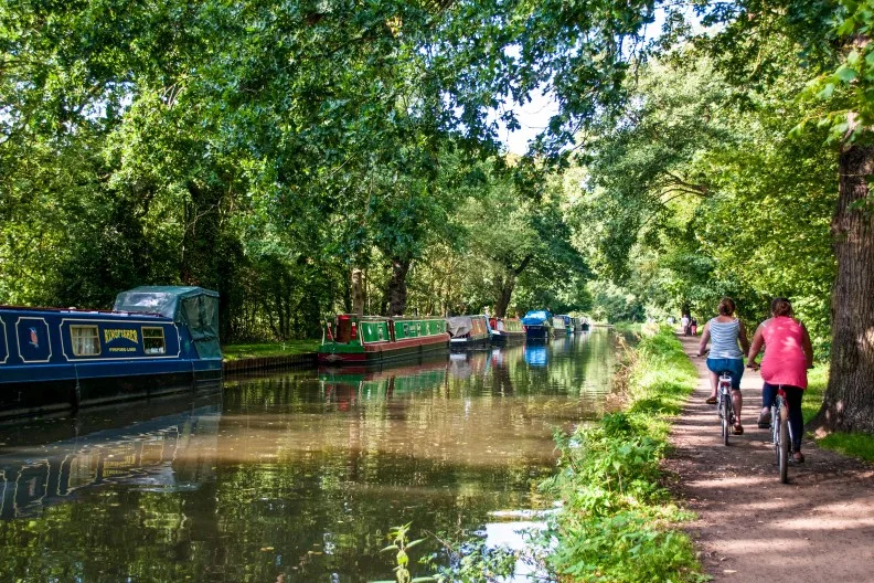 Narrow boats moored along the River Wey Navigation in Surrey, England, UK