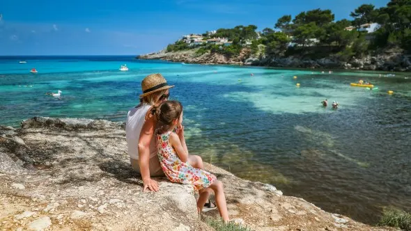 Familie beim Abendessen im Freien auf der Terrasse einer Finca auf Mallorca.