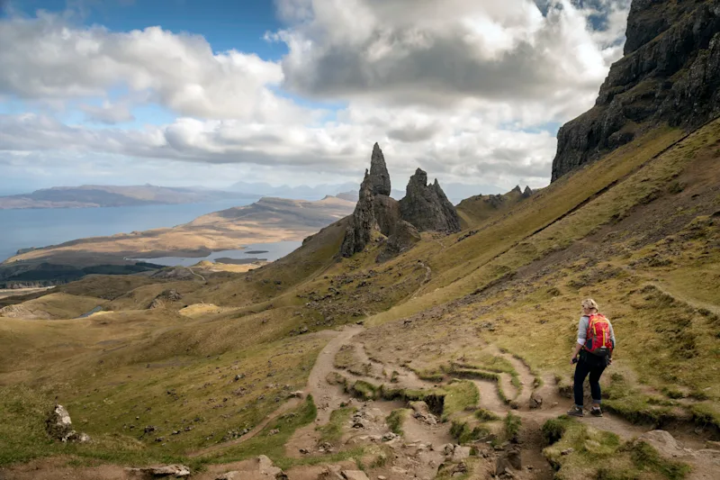 A woman hiking to the Old Man of Storr on the Isle of Skye, Scotland, UK