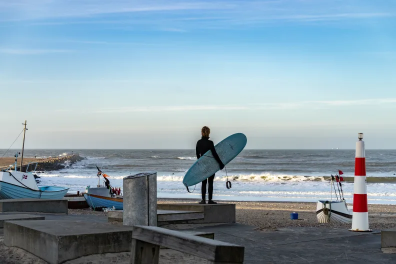 Ein Surfer am Strand in Cold Hawaii, Klitmøller an der Nordsee in Dänemark