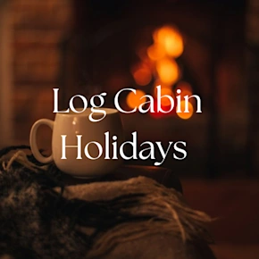 Mug with hot tea standing on a chair with woolen blanket in a cozy living room with fireplace.