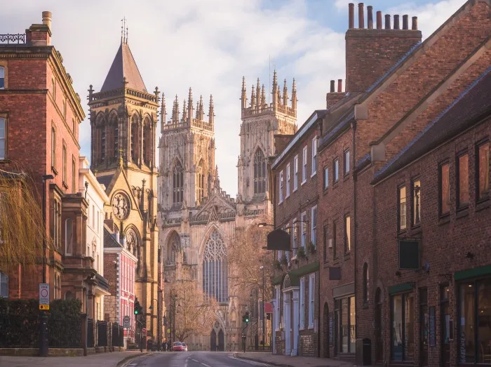 Morning golden light on the historic old town of York along Museum St. looking towards York Minster Cathedral in Yorkshire