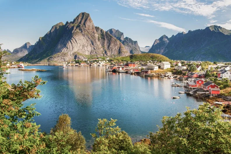 Reine Fischerdorf auf den Lofoten, Norwegen. Das Dorf Reine unter sonnigem, blauem Himmel, mit den typischen Rorbu-Häusern.