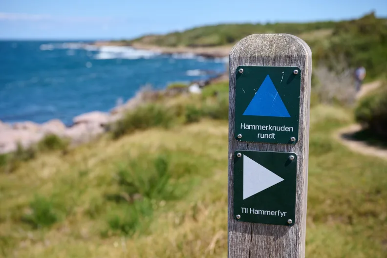 Wandermarkierung auf Bornholm. Meer im Hintergrund.