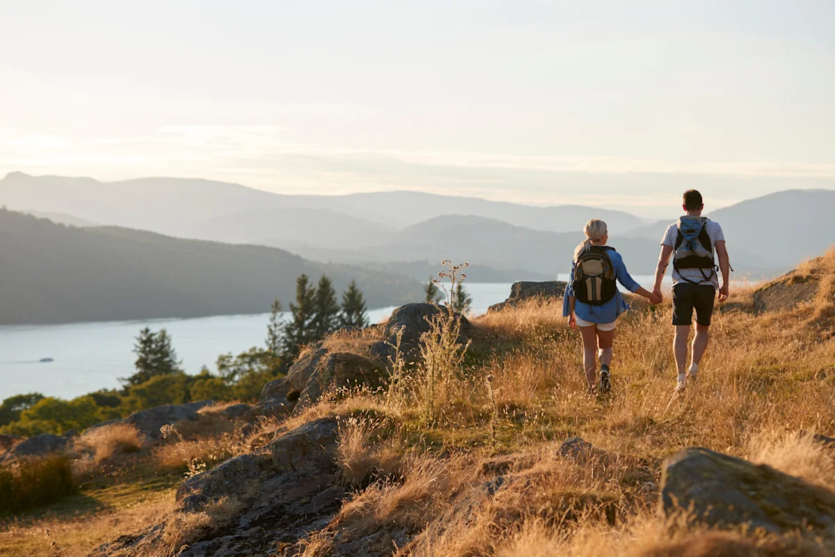 Couple walking hand-in-hand in the Lake District National Park. Cumbria, England, UK