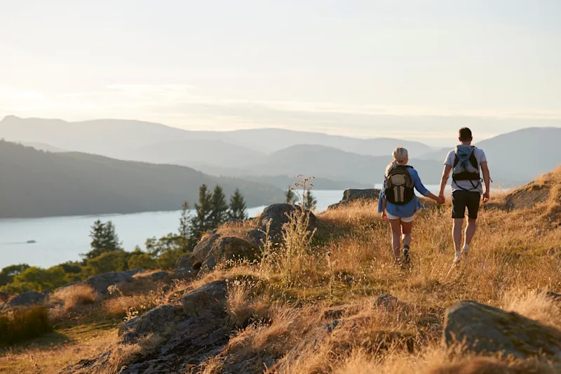 Couple walking hand-in-hand in the Lake District National Park. Cumbria, England, UK