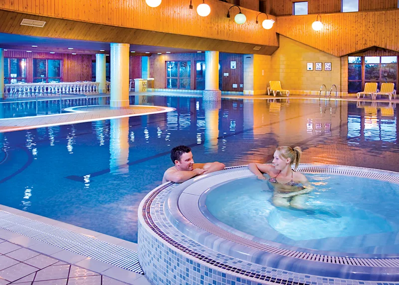 Couple relaxing in the indoor pool and spa bath at Crowhurst Park Lodges (CROW) in Battle, East Sussex, England, UK
