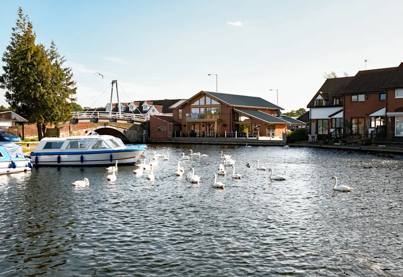 View of the Water's Edge next to the bridge in Wroxham, overlooking the River Bure on the Norfolk Broads, England, UK