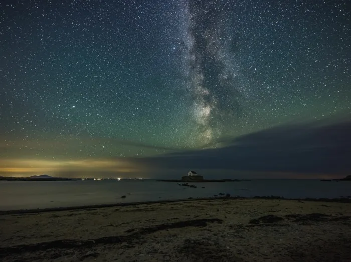 Milky Way and night sky over St Cwyfans Church at Anglesey, Wales