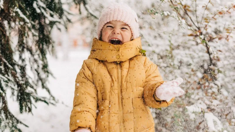 Toddler girl happy with snow day in winter.