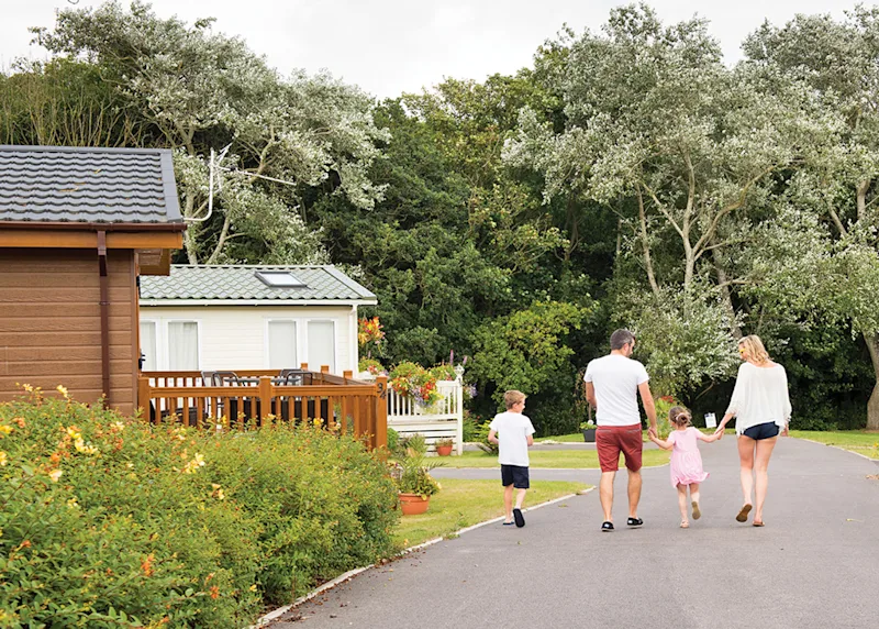 Family walking through the grounds of Shorefield Country Park (SHCO) in Milford-on-Sea, Nr Lymington, Hampshire, England, UK