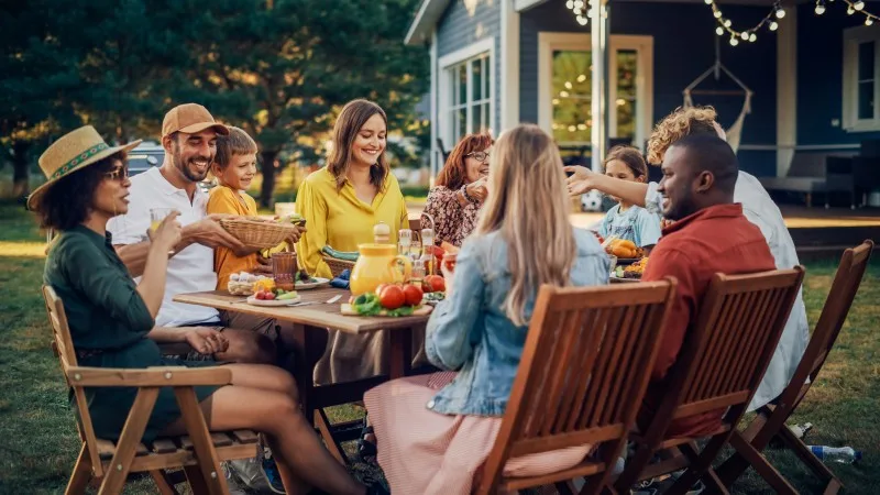 Parents, Children, Relatives and Friends Having an Open Air Vegetarian Dinner in Their Backyard. Old and Young People Talk, Chat, Have Fun, Eat and Drink.