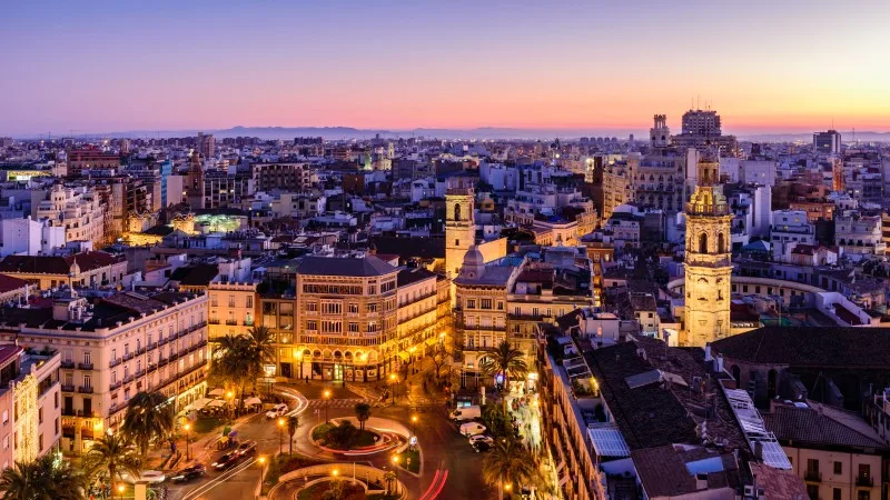 Sightseeing of Spain. Aerial view of Valencia at sunset. Illuminated Plaza de la Reina, cityscape of Valencia.
