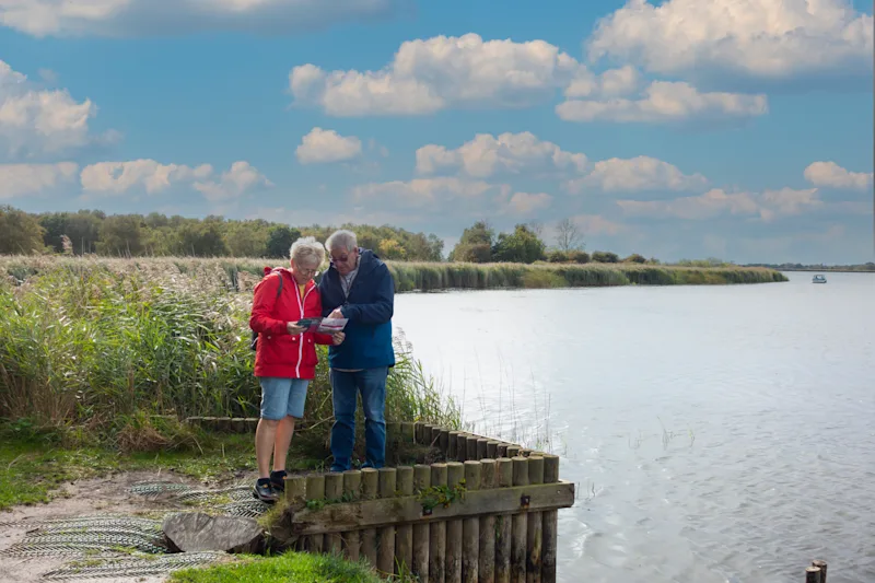 A couple consulting their map whilst out for a walk on the Norfolk Broads, England, UK