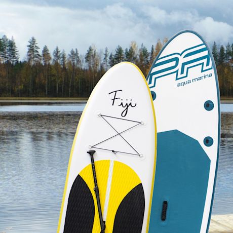 Kaksi SUP-lautaa järven laiturilla: valkoinen-keltainen Fiji ja valkoinen-sininen Aqua Marina