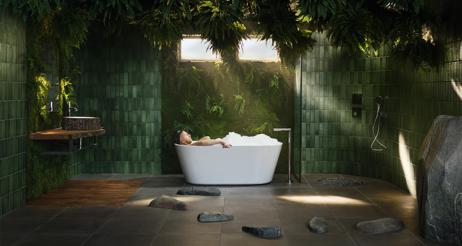 Mies nauttii kylvystä metsä-teemaisessa kylpyhuoneessa.