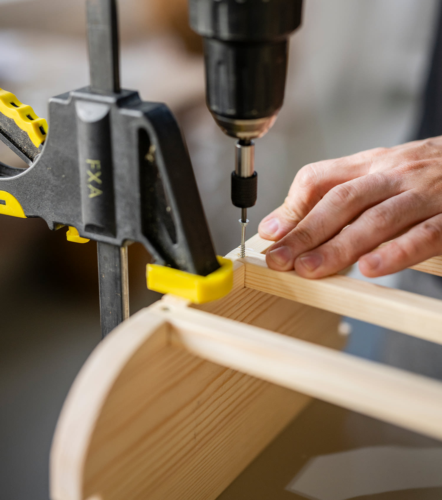 Sadonkorjuukori rakentuu itse. Kuvassa mies poraa ruuveja kiinni.