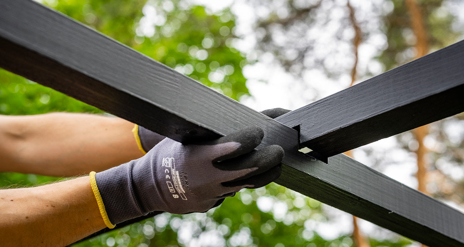 Modernin pergolan rakentaminen. Kuvassa ristikkäispalkkien kiinnitys.