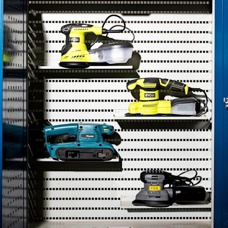 Hyllyllä neljä sähköistä hiomakonetta: kaksi keltaista Ryobiä, turkoosi Makita ja harmaa FXA.